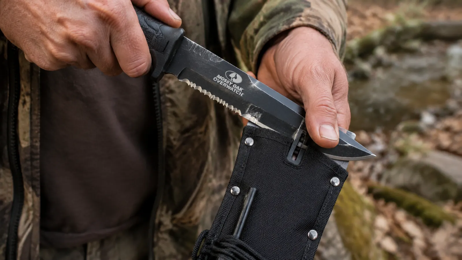 Close-up of hands drawing a fixed blade knife across a compact pull-through sharpener built into a knife sheath